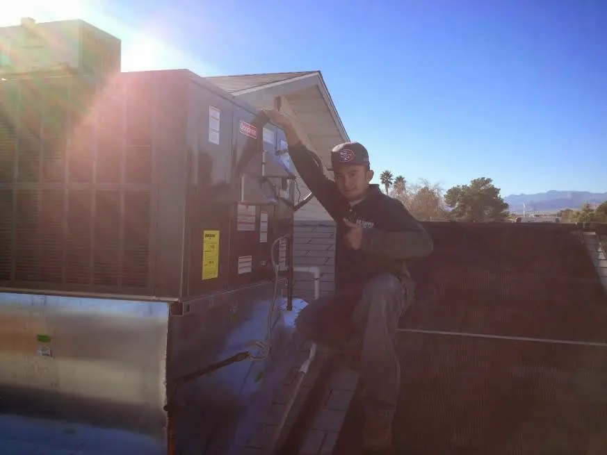 HVAC technician performing HVAC Inspection on a rooftop unit in Clayton
